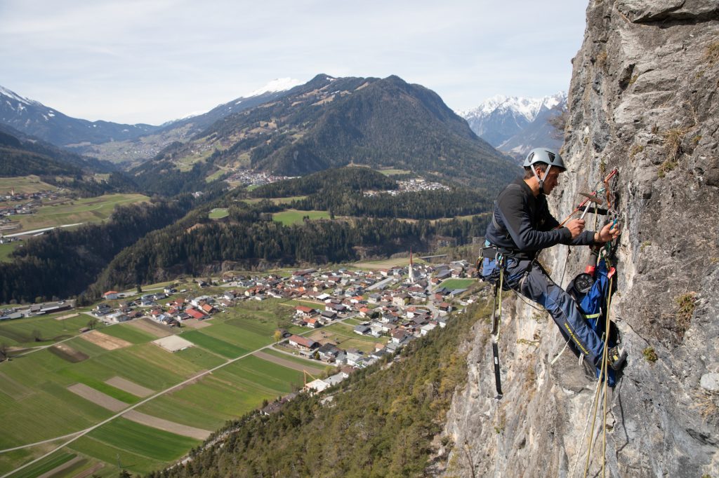 Das Bild zeigt einen Kletterer bei der Wartung von Klettergärten im Climbers Paradise.