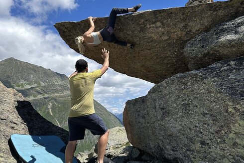 Eine Klettererin wird gesichert durch einen jungen Mann