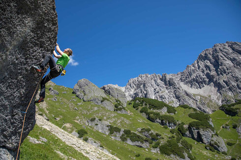 After the approach by bike, the woman climbs a sport climbing route on the rock.