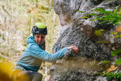 Eine Sportlerin steigt in eine Klettertour ein