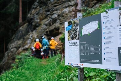 Eine Gruppe Kletterer informiert sich vorm dem Klettern beim Guide