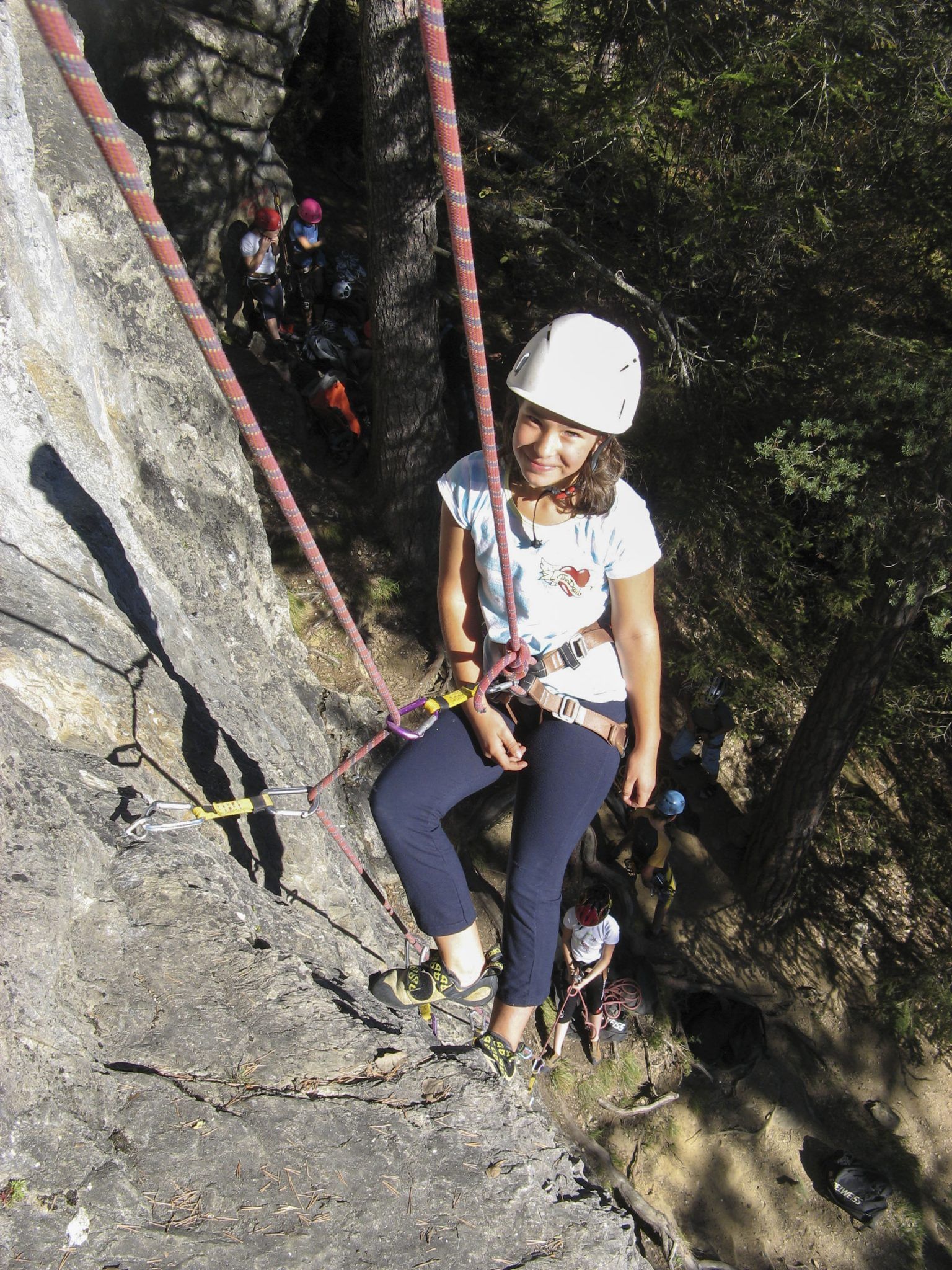 Kind mit Helm klettert im Klettergarten Putzen