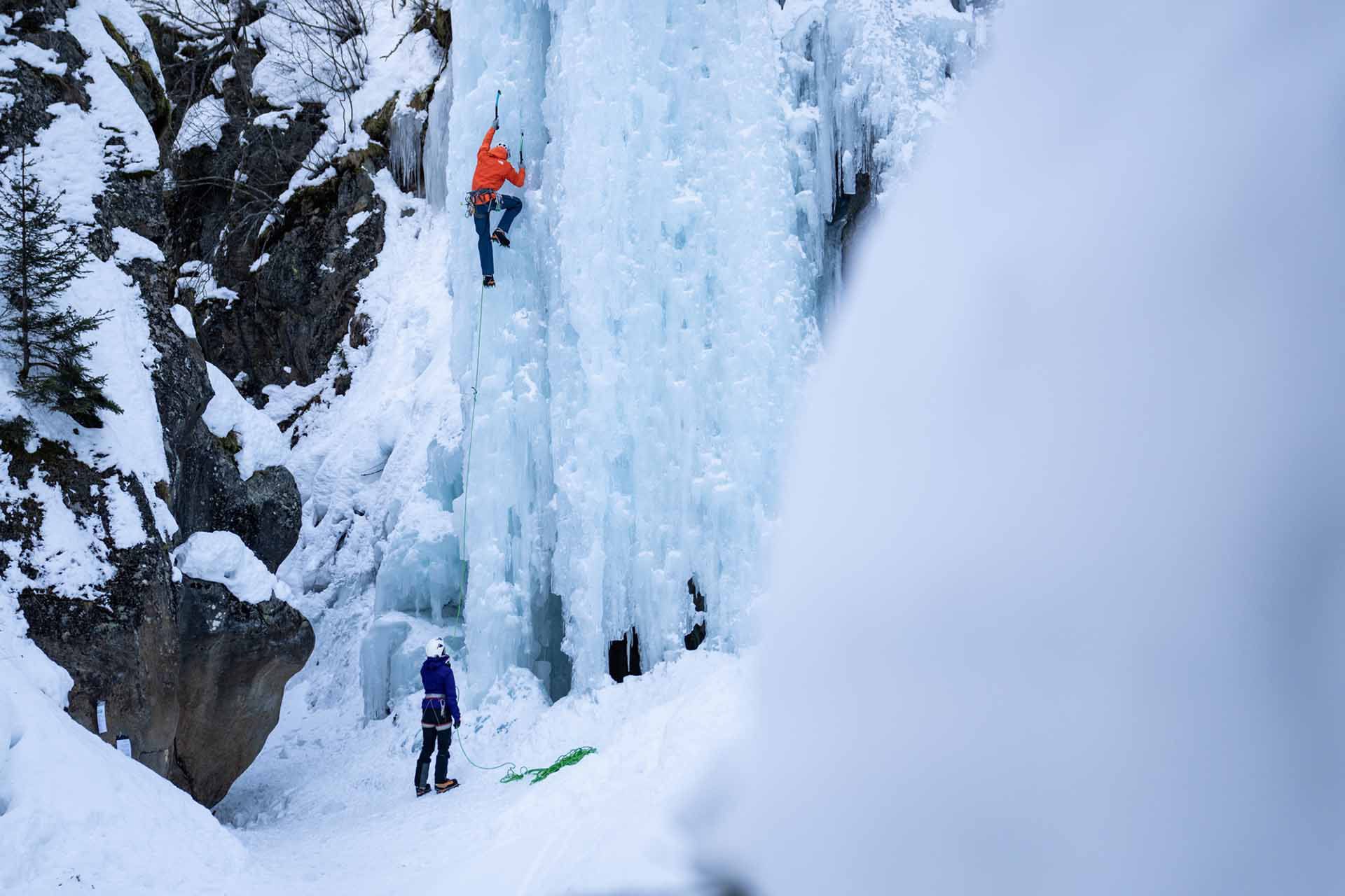 Eine Person klettert in einer steilen Eiswand