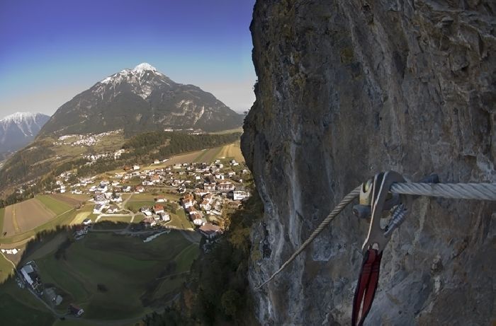 Person am Klettersteig Steinwand, darunter Arzl im Pitztal