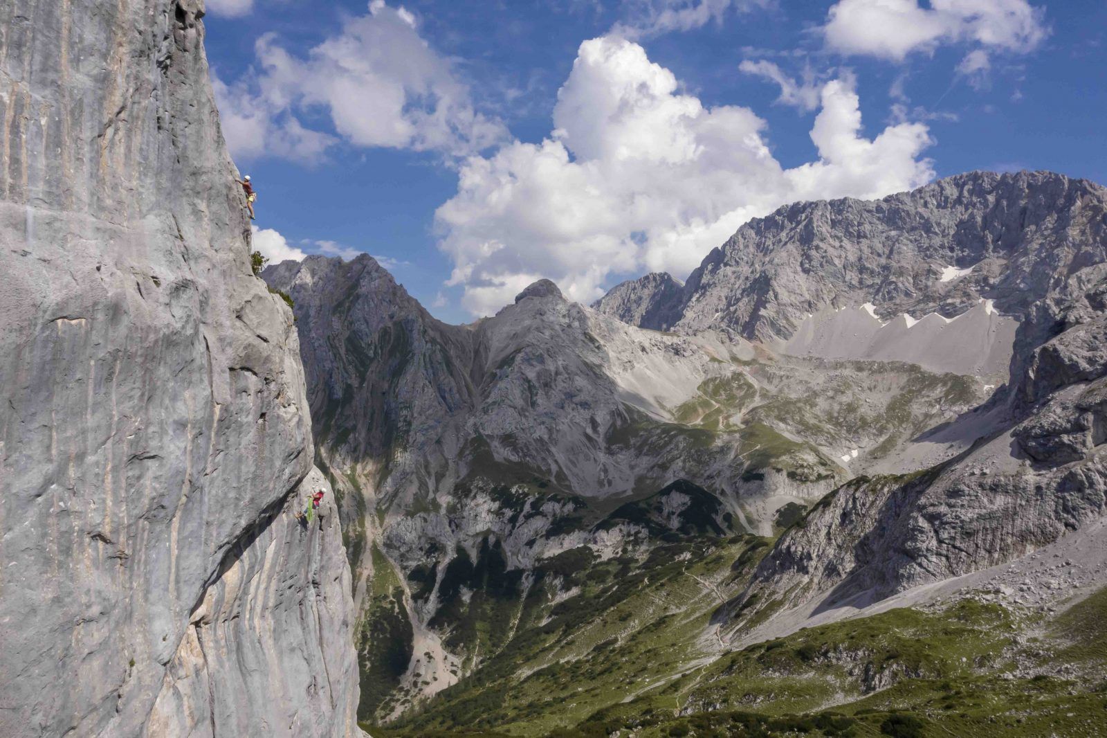 Kletterin in der dritten Seillänge der Route Boomerang mit weitem Blick über die Mieminger Kette