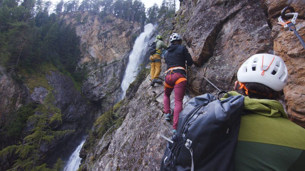 Two via ferrata climbers one behind the other on the wire rope