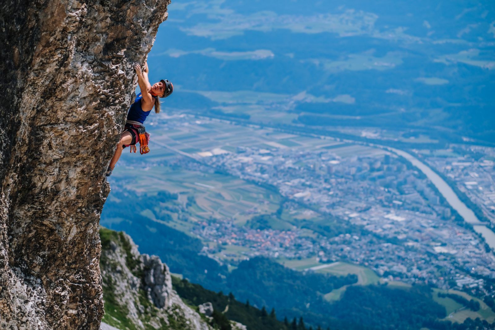 Katha Saurwein klettert in der Kletterarena Seegrube, darunter die Stadt Innsbruck