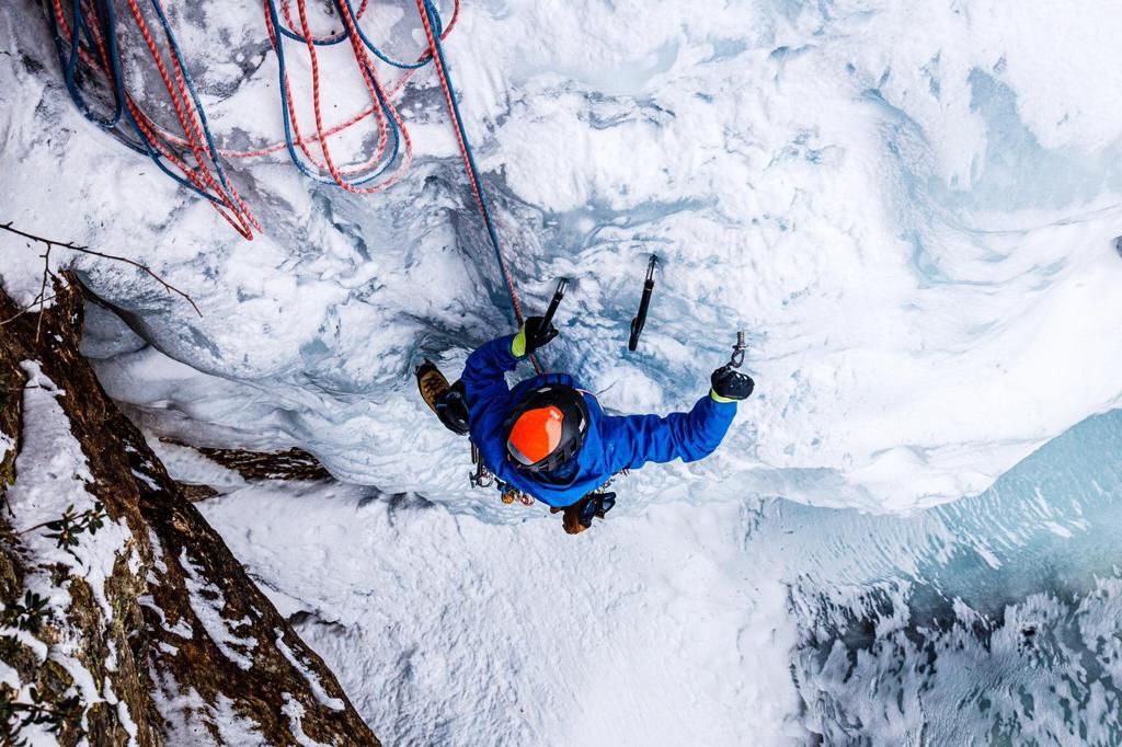 Eiskletterer dreht eine Eisschraube im Stubaital