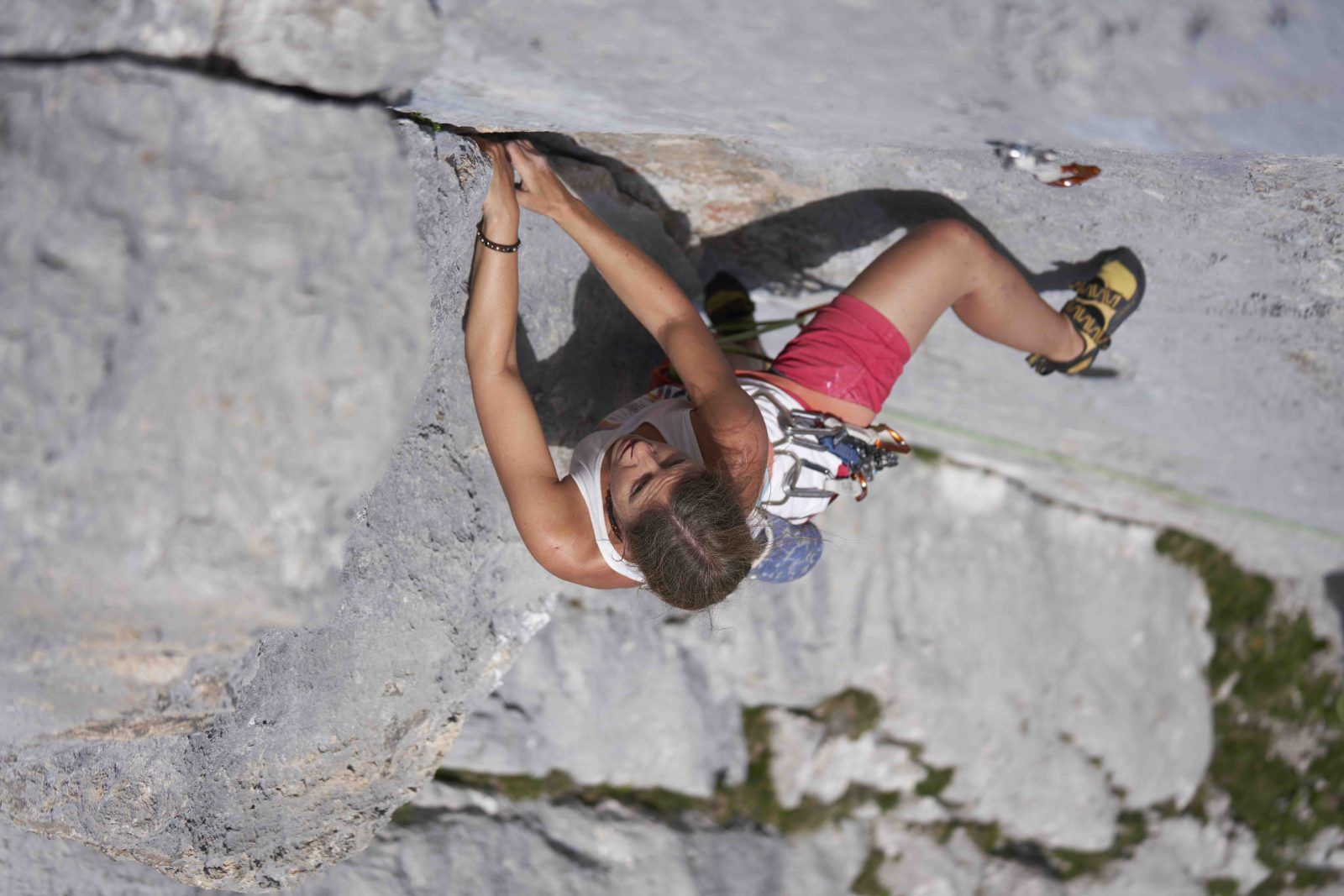 Kletterin greift im überhängenden Dach die Schlüsselstelle der Route Boomerang