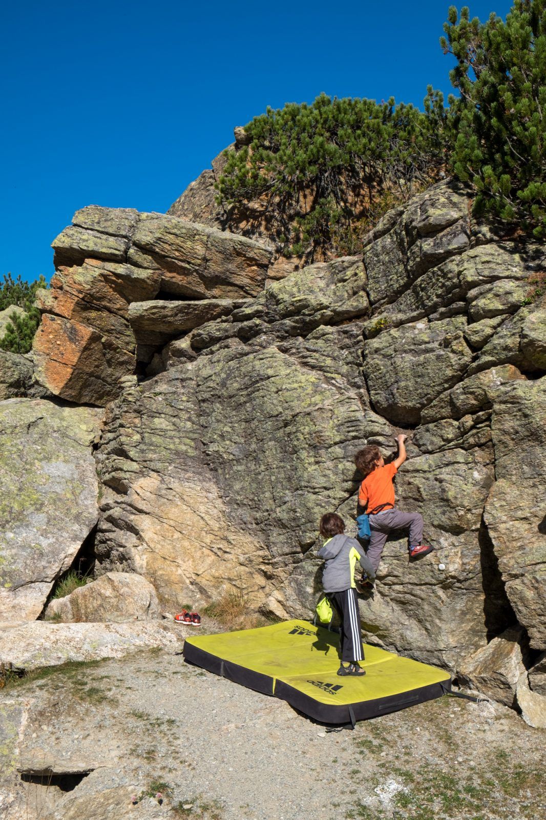 A child bouldering on a low boulder