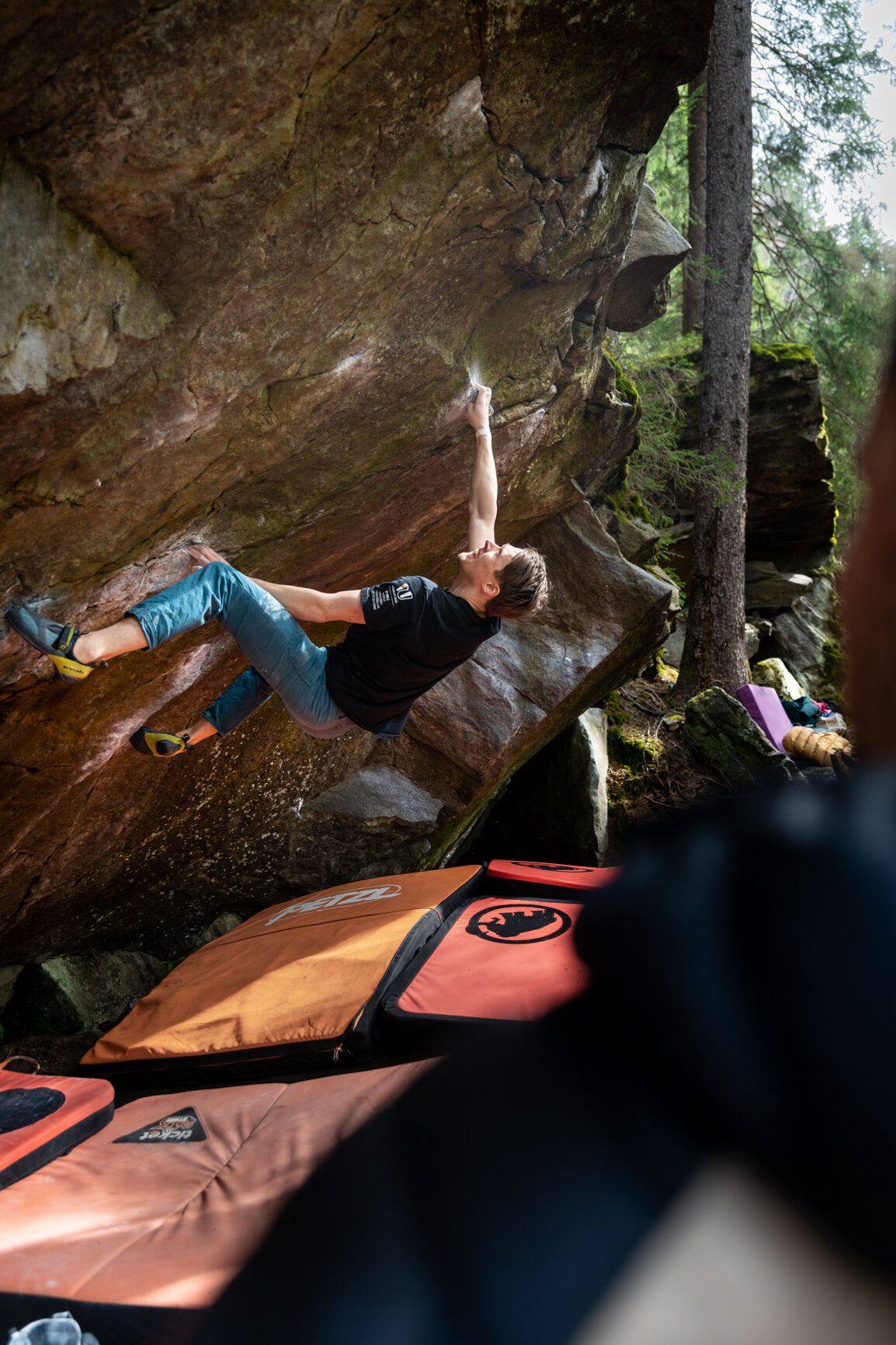 Boulderer mit Matten am Fels im Überhang