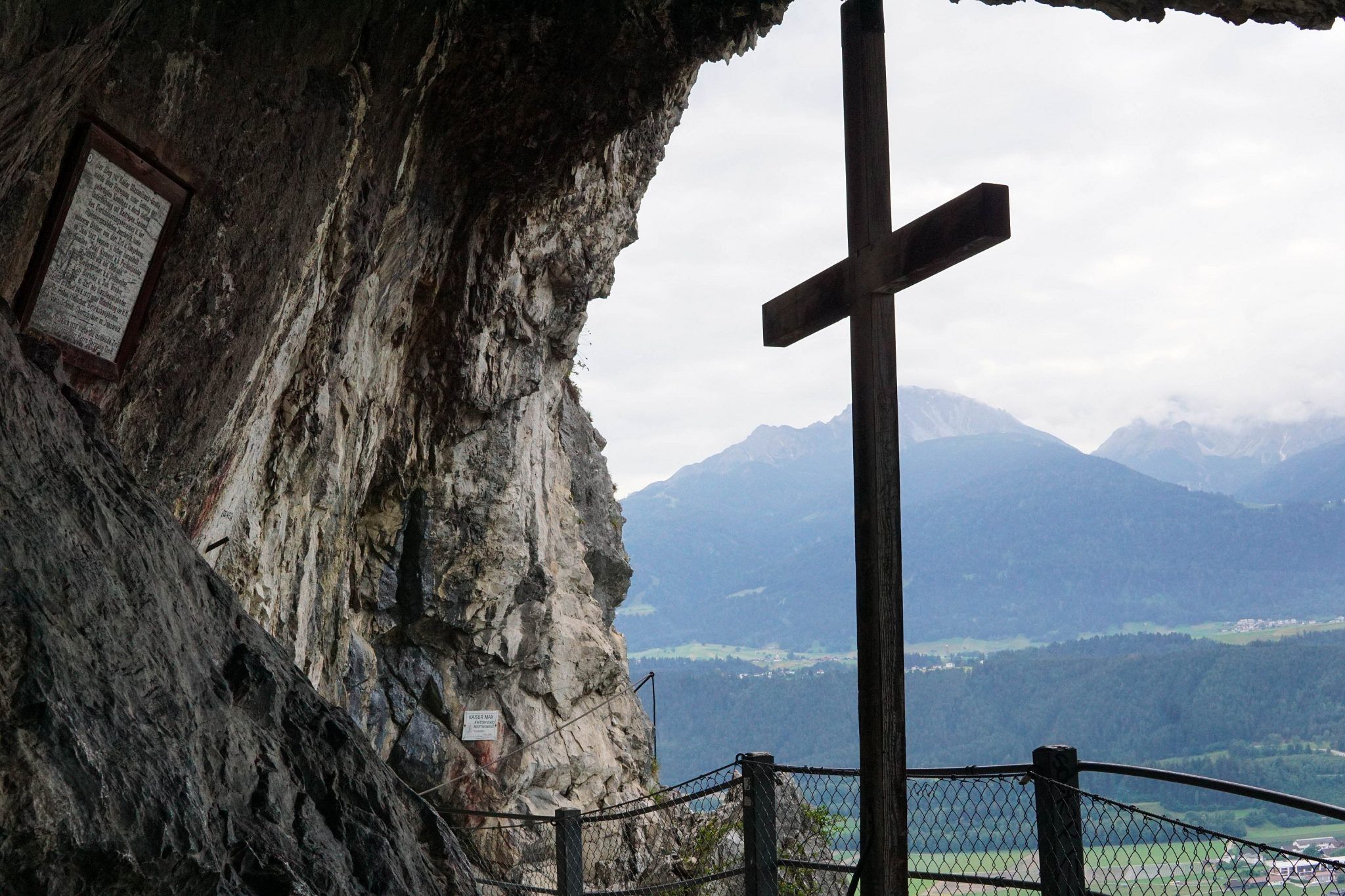 Blick aus der Maximiliansgrotte mit Holzkreuz über das Inntal