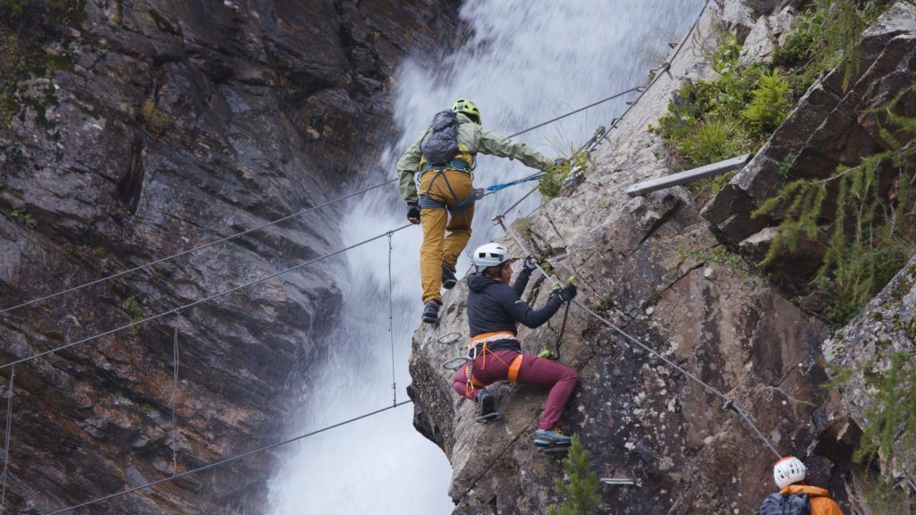 Via ferrata climbers on iron clamps in a B-section