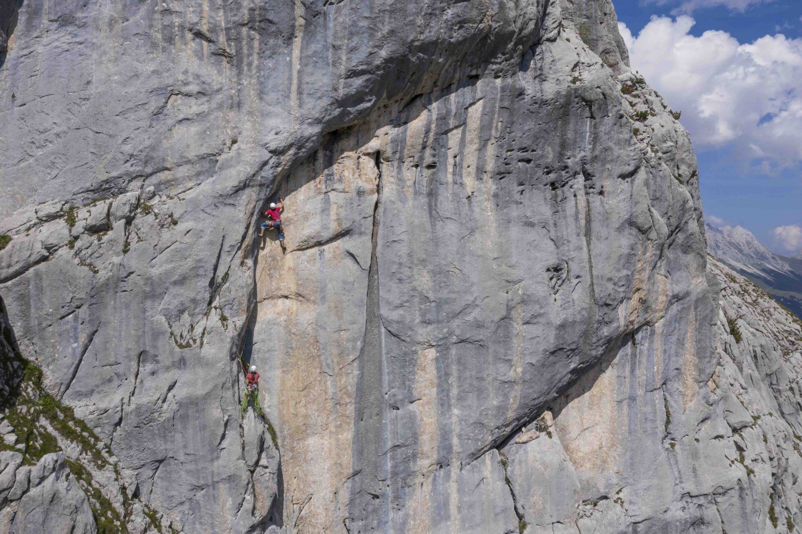 Zwei Kletterinnen in einer großen grauen Wand aus Wettersteinkalk