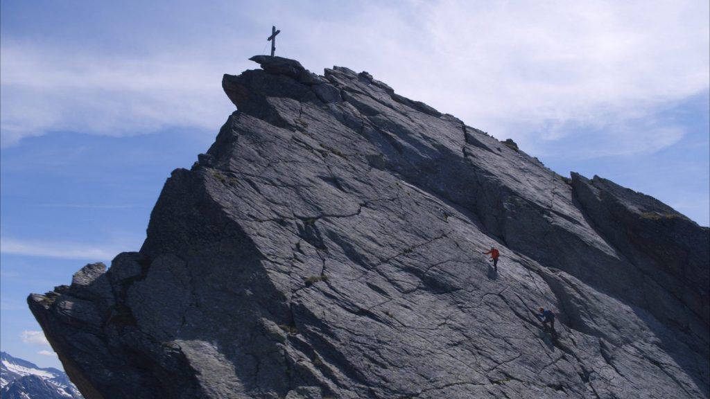 Via Ferrata/Iron Way climbers on an alpine Via Ferrata/Iron Way with a view of the summit