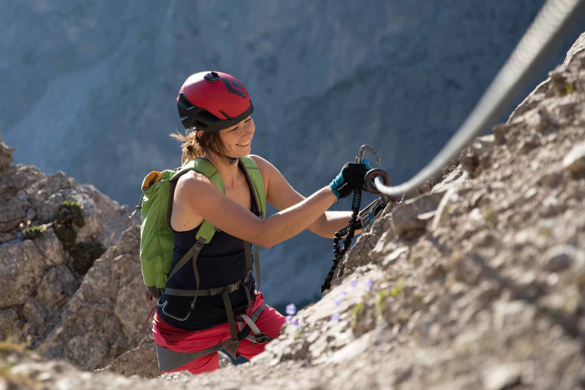Eine Frau sichert sich beim Klettersteigen. 