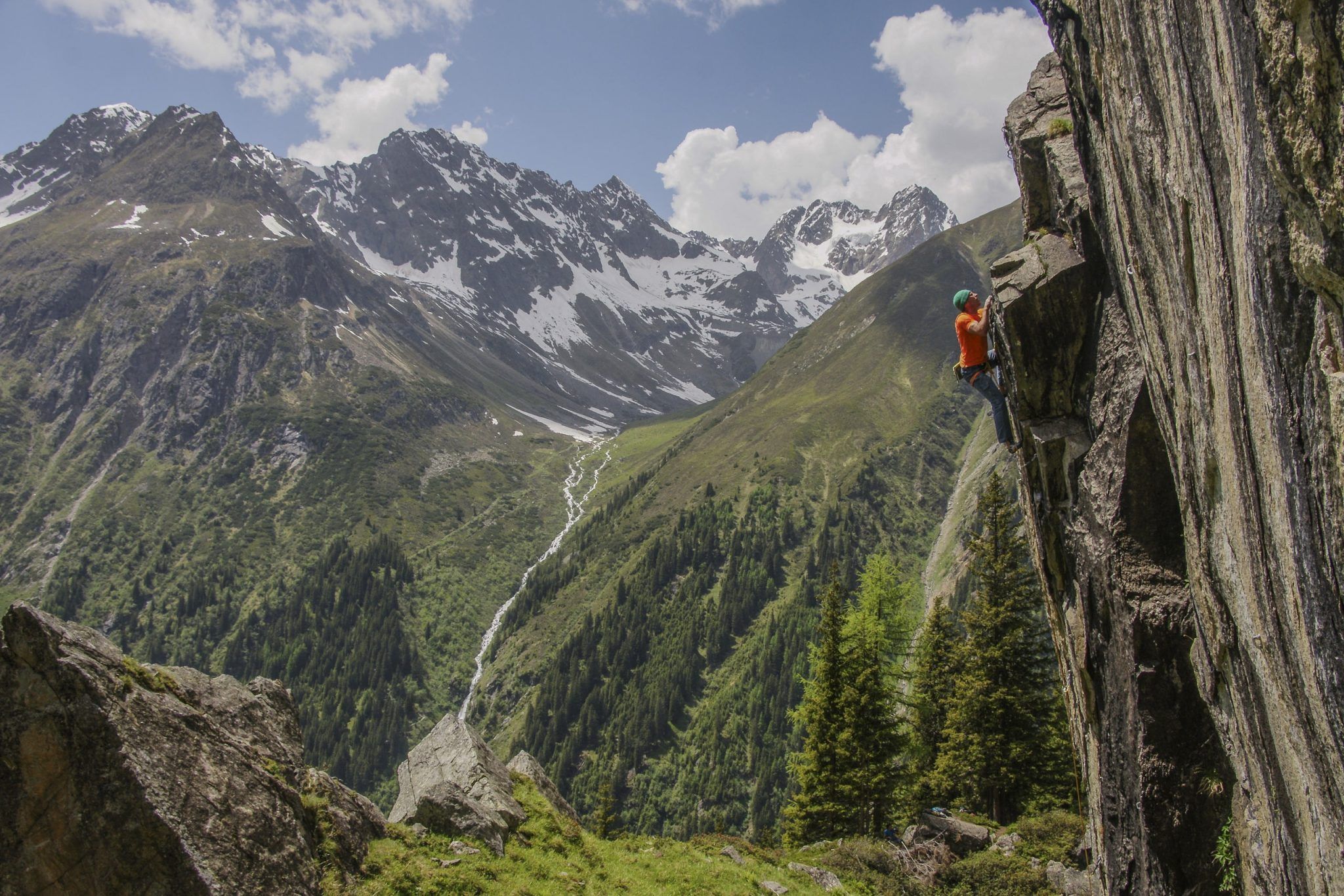 Kletterer an einer Gneiswand im Hexenkessel, dahinter das Pitztal und vergletscherte Gipfel