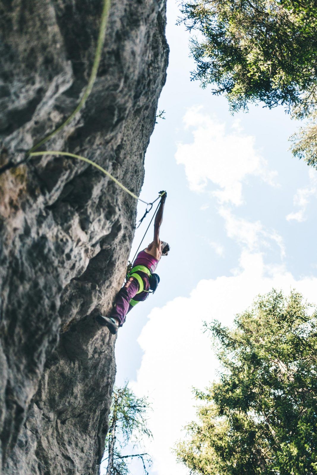 A female climber on the conglomerate boulders at the Reithle Crag near Imst
