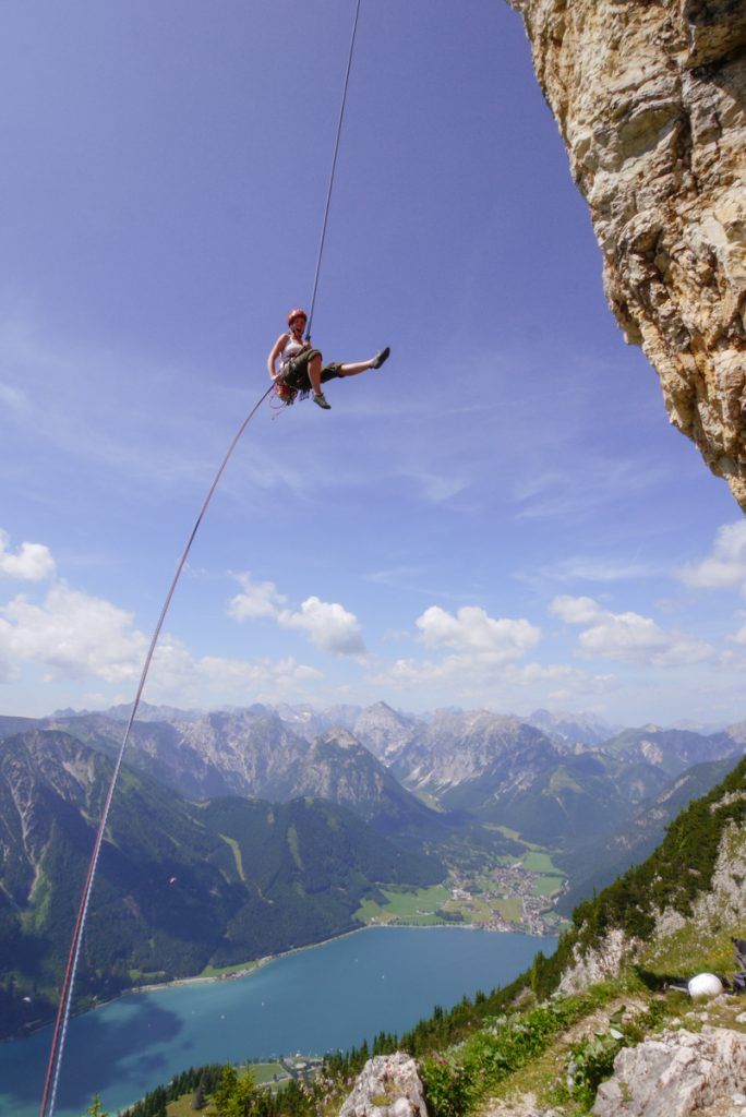 Climbers abseiling down the Rotspitz with a view down to Lake Achensee