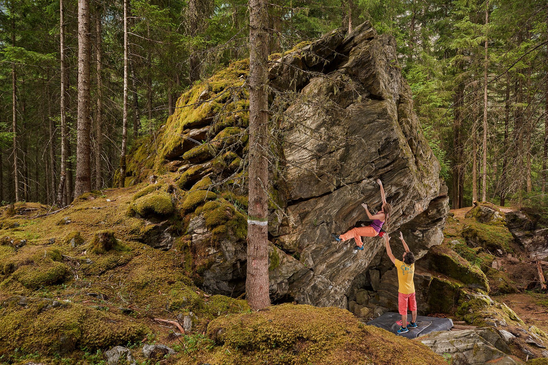 Zwei Sportler am Bouldern im Wald